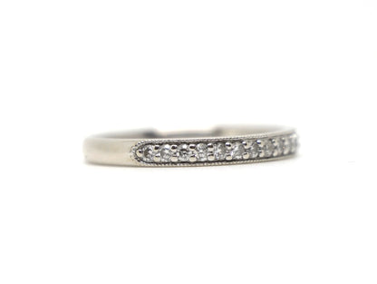 18ct white gold diamond half eternity ring, set with round brilliant cut diamonds across the top half of the band and edged with fine milgrain detail along both sides